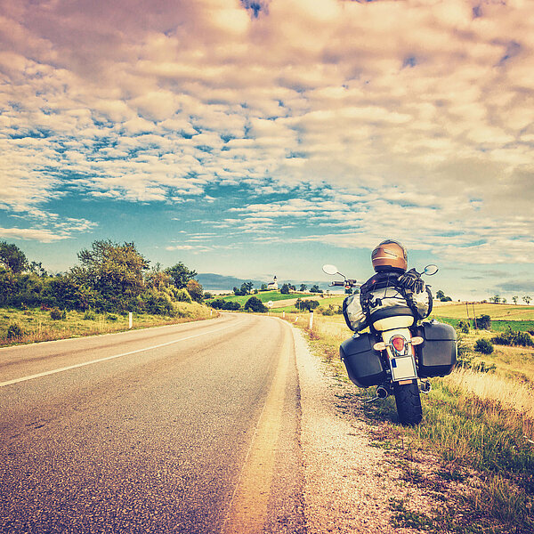 Bei einer Motorradreise wird am Straßenrand eine Pause gemacht